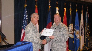 In January, Col. Platt (r) presents a certificate to Col. Michael Finn II, USAF, commander of the 50th Network Operations Group, 50th Space Wing, Schriever Air Force Base, for a scholarship fund donation.